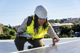 Woman engineer installing or maintaining solar panels on a rooftop, symbolizing renewable energy,