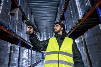 Worker in a safety vest and warm jacket performing inventory management, scanning product barcodes