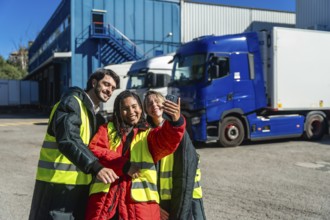 Diverse logistics team members smiling and taking a selfie outside a cold storage warehouse with
