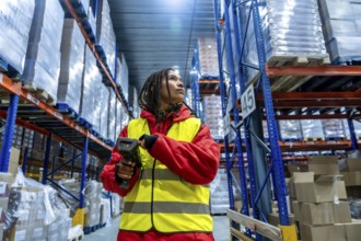 Worker in safety vest and warm jacket using a barcode scanner to manage inventory, ensuring