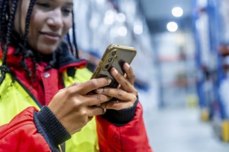Logistics professional checking inventory with a mobile phone, optimizing cold chain operations and