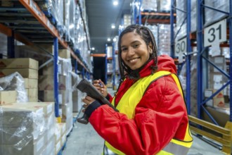 Latin american warehouse worker smiling while using a barcode scanner to perform inventory checks