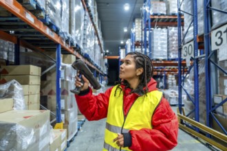 Worker wearing protective clothing and a high visibility vest scanning boxes on tall racks,
