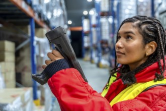 Woman worker performing stocktaking, scanning products in a refrigerated warehouse, maintaining