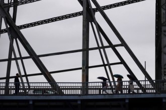 Passers-by with umbrella on a bridge, autumn, rainy weather, Germany