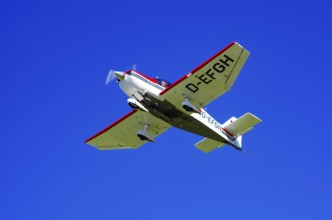 A Robin DR 400/200R Remorqueur light aircraft, registration D-EFGH, tows a glider during a flight