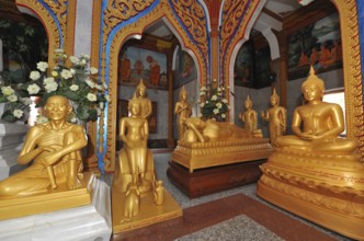 Prayer room devotional room with golden statues from left Monk and Buddha in the temple complex Wat