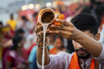 A Hindu devotee offer prayers to the Sun God on the bank of Brahmaputra river on the occasion of