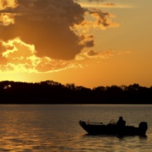 A boat on Lake Gudelack at sunset, Lindow (Mark), Stechlin-Ruppiner Land nature park Park,