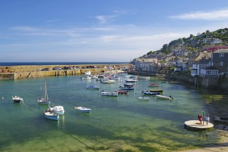 Small harbour with numerous boats and houses along the wharf, Mousehole, Cornwall, Great Britain