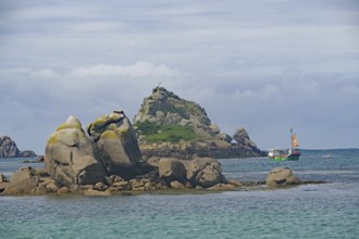 Rocks and small island in the sea accompanied by boats and slightly cloudy sky, Isles of Scilly,