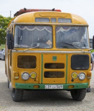 An old orange bus with retro design parked on a street, PAZ-672, minibus from Soviet manufacturer