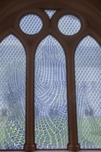 Colourful stained glass window with geometric patterns, the Pietà window by Thomas Bayrle, in the