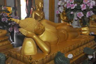 Reclining Buddha in golden color resting head on hand Unteram, Wat Chalong Monastery, Phuket