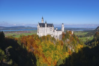 The fairytale Neuschwanstein Castle with autumn trees and views of the surrounding countryside,