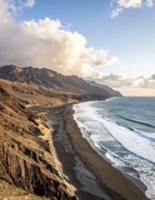 Desert landscape converges with ocean along a rugged coastal area, shore break at cliffs, blue