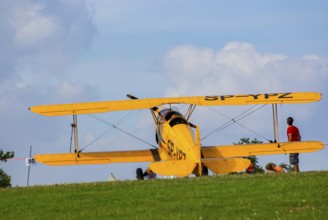 A Bücker Bü 131 Jungmann biplane parked at the edge of the airfield, SP-YPZ registration, as part