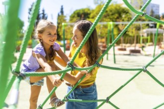 Mother and daughter bonding through playful activity, climbing together on a green rope net