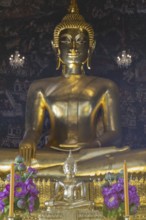 Golden Buddha statue, Phra Buddha Trilokachet surrounded by crystal chandeliers and exquisite wall