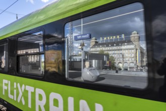 Flixtrain train on track 2 in Essen main station, reflection of the Handelshof building, city,