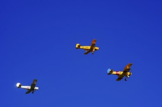 Three biplanes, a Boeing PT-17 Stearman, a Stampe-Vertongen SV-4B and a Bücker Bue 131 Jungmann fly