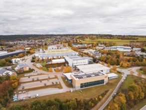 Industrial buildings and warehouses in a landscape with autumn trees and cloudy sky, Dornstetten,