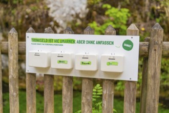 Sign on a wooden fence with a humorous message about tips, Wimsener Höhle, Hayingen, Germany
