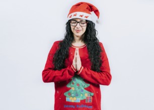 Hopeful Young woman in Christmas sweater making a wish, isolated. Hopeful girl in Christmas hat