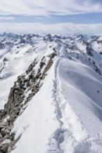 Narrow mountain ridge in winter, summit of Piz Grialetsch, view of mountain panorama with snow,