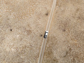 Top-down view, aerial view, car on lonely road in dry countryside, Botswana