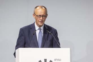 Federal Chancellor Friedrich Merz (CDU) . Portrait at the lectern with free text space.