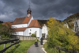 Cyclists on the Danube Valley Cycle Path in front of St. George's Basilica at Käppeler Manor near