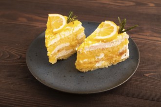 Lemon cake on brown wooden background, side view, copy space