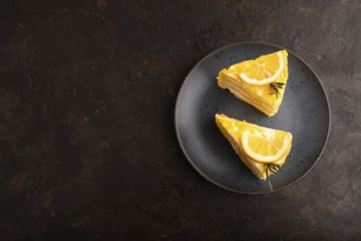 Lemon cake on black concrete background, top view, flat lay, copy space