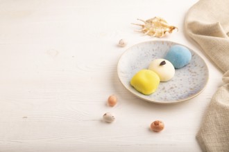 Japanese Mochi Cakes on white wooden background and linen textile, side view, copy space