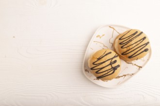 Caramel Cream Cakes on white wooden background, top view, flat lay, copy space