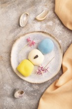 Japanese Mochi Cakes on brown concrete background and orange textile, top view, flat lay, close up