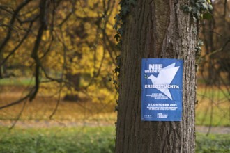 Poster on a tree trunk, call for a demonstration against war, peace demo, dove of peace, day of