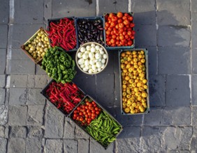 Traditional Mexican plaza with crates of peppers, onions, and tomatoes, economic prosperity in