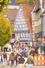 Street festival in the old town with half-timbered houses, people and colorful balloons in autumn,