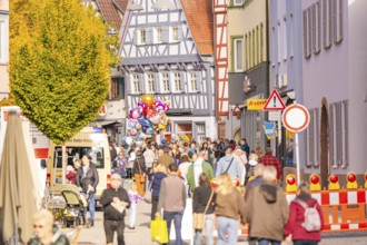 View of a busy street with half-timbered houses, construction site and crowd in the city,
