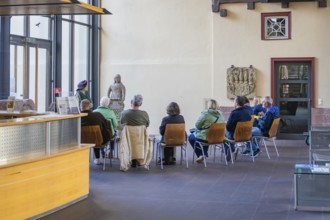 Group of people sitting in a museum room looking at sculptures, Urschelherbst Street Festival,