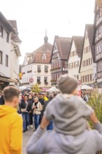 Families and visitors enjoy a market day in a picturesque old town, Urschelherbst Street Festival,