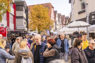 Lively pedestrian zone with autumn colors and traditional buildings, full of people, Urschelherbst