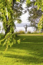 Parkland with a sculpture and view of the lake, surrounded by lush nature, Überlingen, Lake