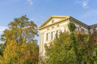 Elegant historic building surrounded by autumn trees under blue sky, Überlingen, Lake Constance,