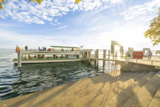 A boat is moored on a jetty in sunny weather, surrounded by calm water, Überlingen, Lake Constance,