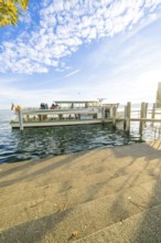 A ship is anchored at a pier on a sunny lake under a clear sky, Überlingen, Lake Constance, Germany