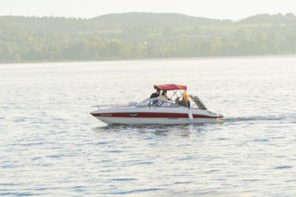 A motorboat with people enjoying a relaxing trip on a quiet lake, Überlingen, Lake Constance,