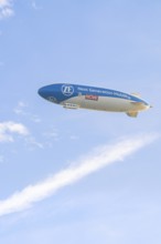 Advertising zeppelin in a clear sky with clouds in the background, Überlingen, Lake Constance,